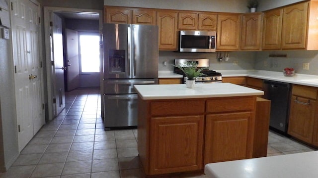 kitchen with light tile patterned flooring, appliances with stainless steel finishes, and a kitchen island