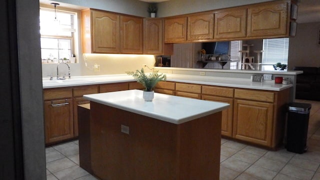 kitchen with a kitchen island, pendant lighting, sink, light tile patterned floors, and kitchen peninsula