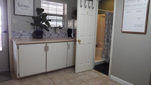 interior space featuring white cabinetry, tasteful backsplash, and light tile patterned flooring