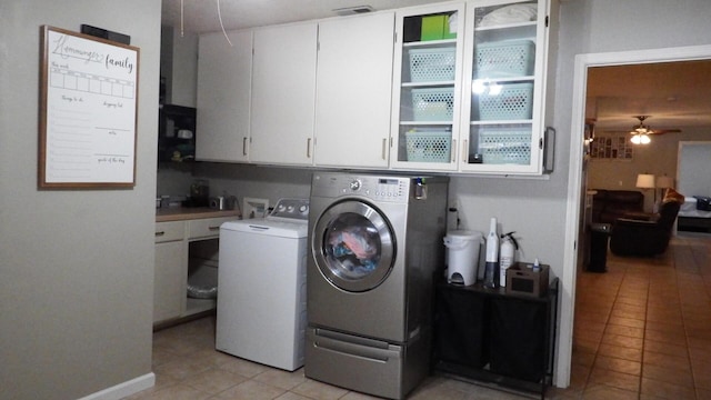 laundry room with ceiling fan, cabinets, separate washer and dryer, and light tile patterned floors