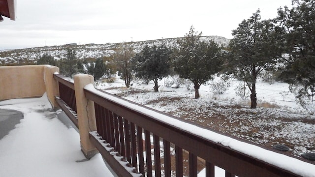 view of snow covered back of property