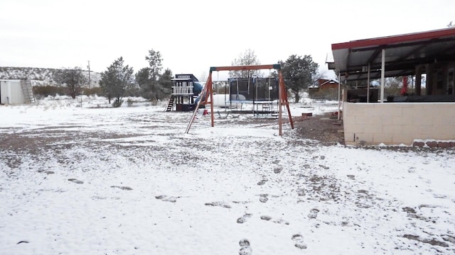 snow covered playground featuring a trampoline