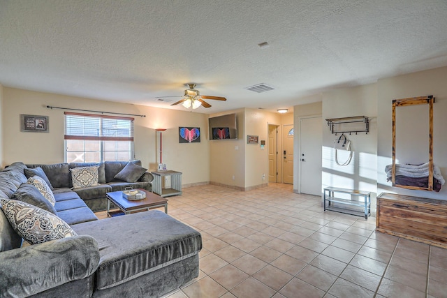 living room featuring light tile patterned floors, a textured ceiling, and ceiling fan