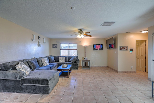 living room featuring ceiling fan, light tile patterned flooring, and a textured ceiling