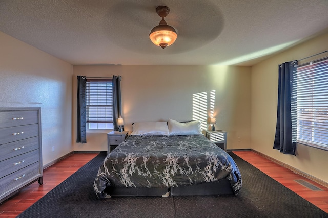 bedroom featuring ceiling fan, a textured ceiling, and hardwood / wood-style flooring