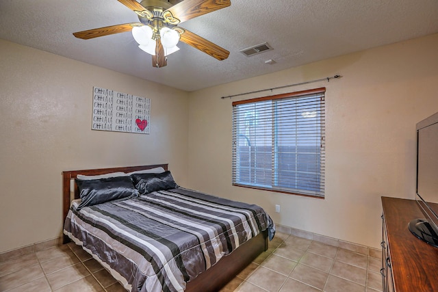 tiled bedroom with a textured ceiling and ceiling fan