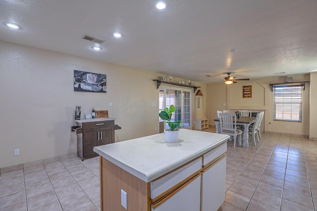 kitchen with a wealth of natural light, a kitchen island, ceiling fan, and light tile patterned flooring