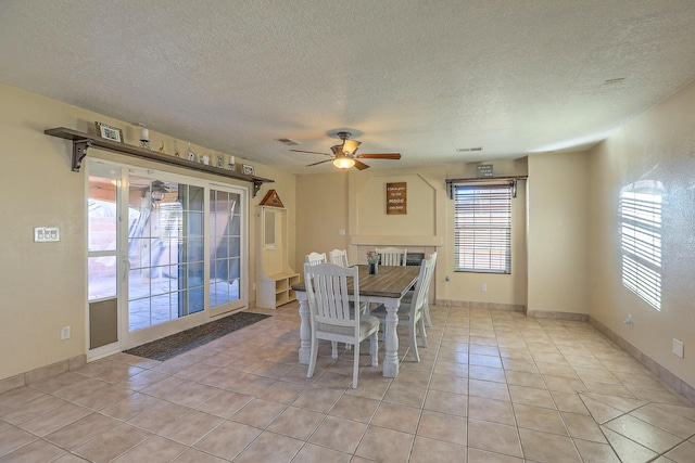 dining room featuring a textured ceiling, ceiling fan, and light tile patterned flooring