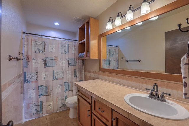 bathroom featuring tile patterned flooring, a shower with curtain, vanity, and toilet