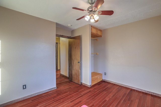 unfurnished bedroom featuring ceiling fan and dark hardwood / wood-style flooring