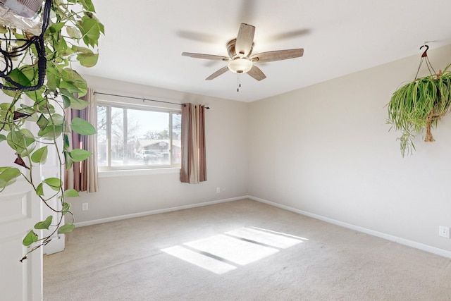 spare room with ceiling fan and light carpet