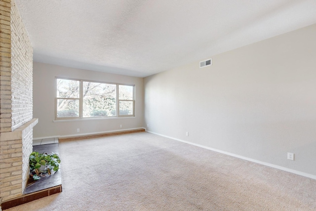 unfurnished living room featuring a textured ceiling, carpet floors, and a fireplace