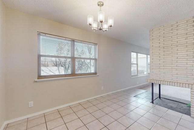 6311 Driscoll Ave NE, Albuquerque, NM 87109 - unfurnished room with a chandelier, a textured ceiling, light tile patterned floors, and baseboards