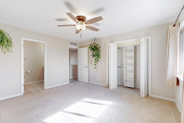 unfurnished bedroom featuring ensuite bath, ceiling fan, a closet, and light carpet