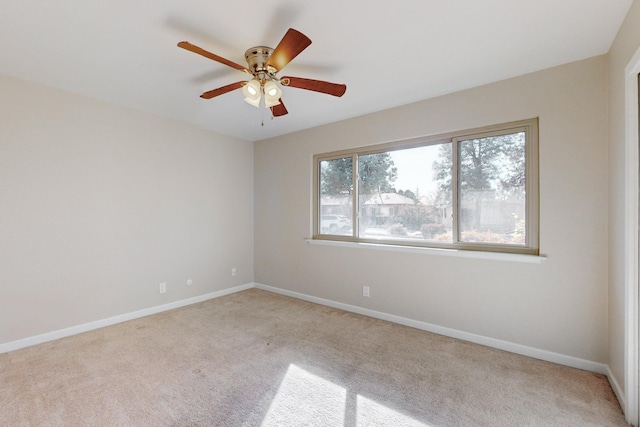 carpeted spare room featuring ceiling fan