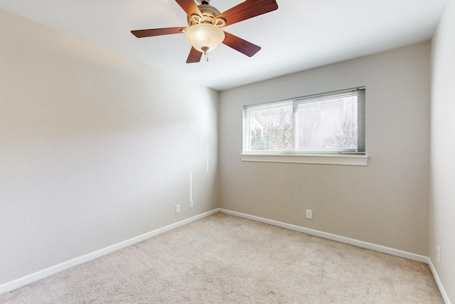 empty room featuring ceiling fan and light colored carpet