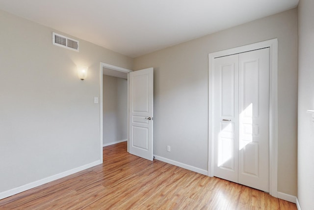 unfurnished bedroom with a closet and light hardwood / wood-style flooring