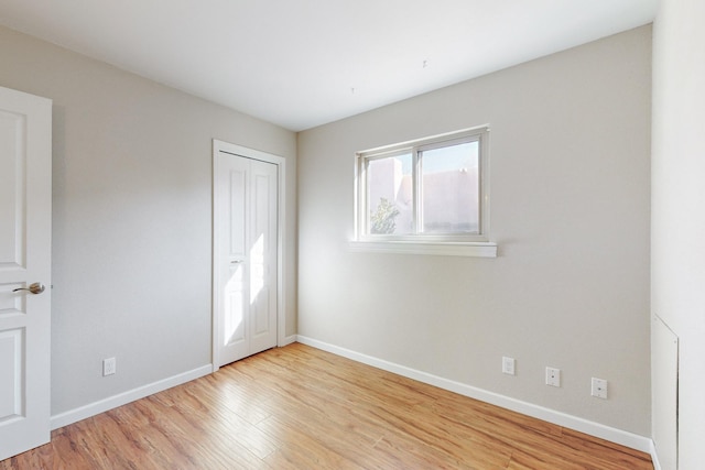 unfurnished bedroom with a closet and light hardwood / wood-style flooring