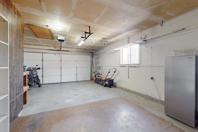 garage with stainless steel fridge and a garage door opener