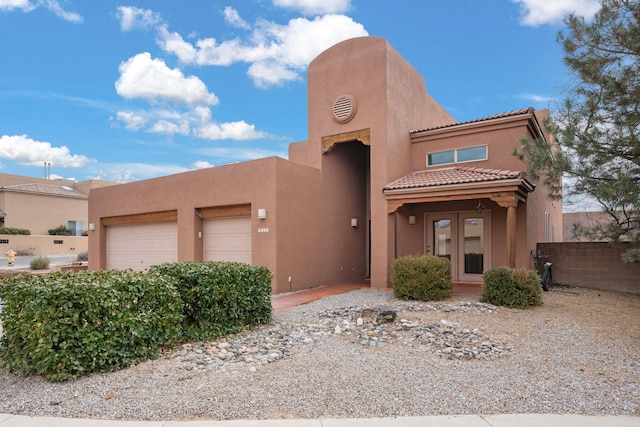 southwest-style home featuring a garage and french doors