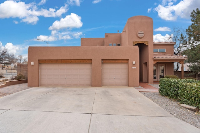 pueblo revival-style home featuring a garage