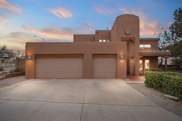 pueblo revival-style home featuring a garage