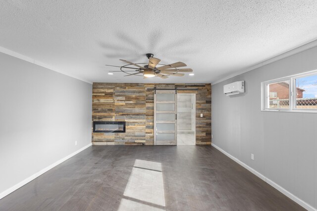 unfurnished living room with a textured ceiling, a large fireplace, a wall mounted AC, and ornamental molding