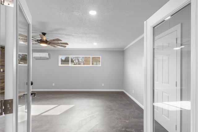 empty room with a textured ceiling, a wall unit AC, ceiling fan, and ornamental molding