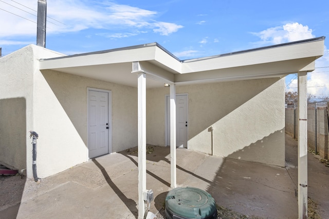 view of exterior entry with a patio