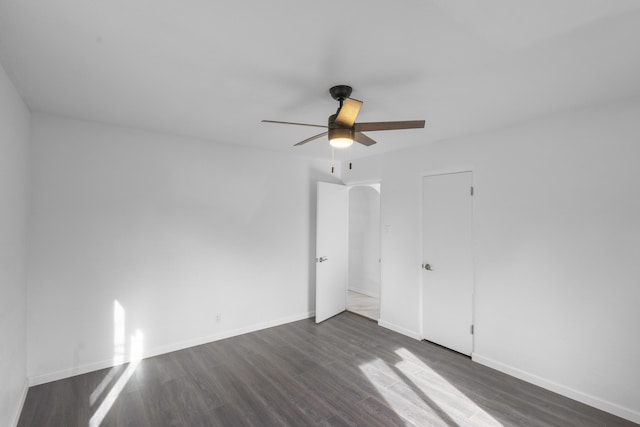 empty room with ceiling fan and dark hardwood / wood-style floors