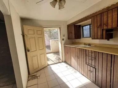 kitchen with ceiling fan, sink, and light tile patterned floors