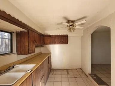 kitchen with ceiling fan, light tile patterned flooring, and sink