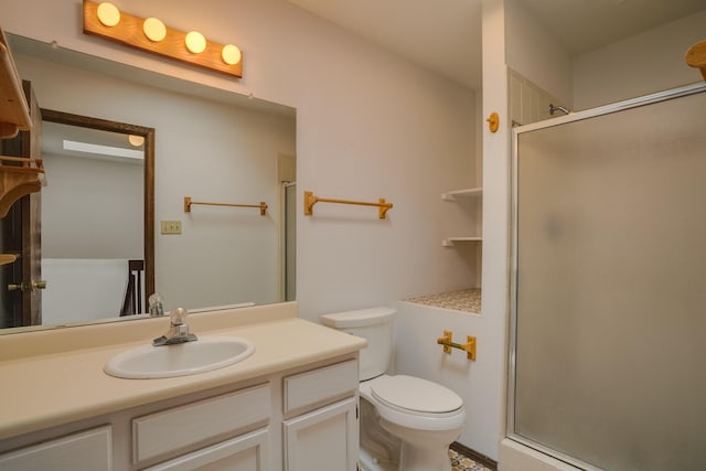 bathroom with vanity, toilet, and a shower with shower door