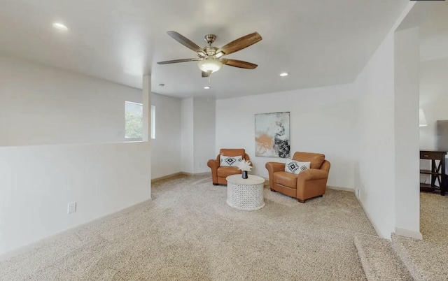 sitting room with ceiling fan and light colored carpet