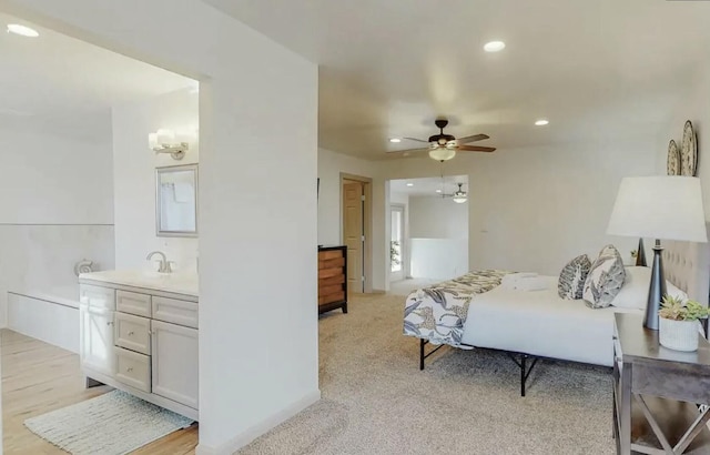 bedroom with light carpet, ceiling fan, and sink