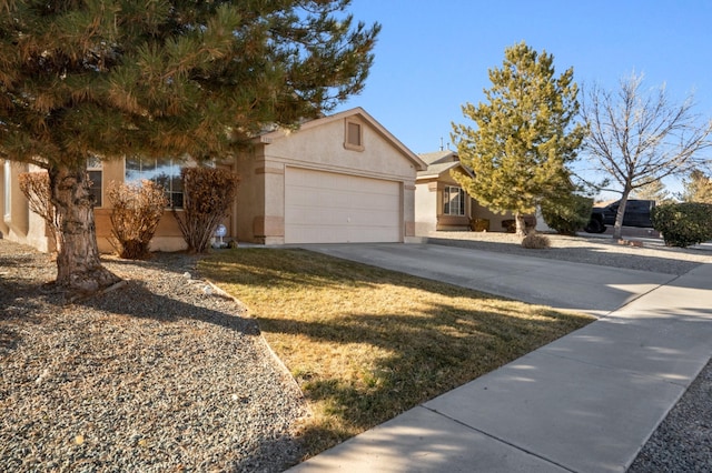 view of front of home featuring a garage, concrete driveway, and stucco siding