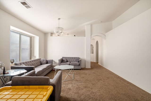 living area featuring carpet floors, visible vents, arched walkways, and a notable chandelier