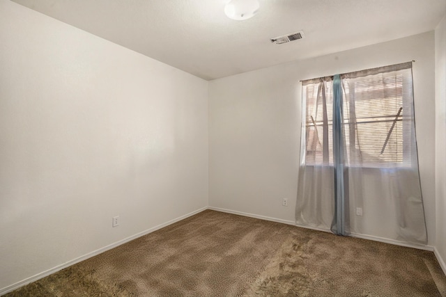 carpeted empty room with visible vents and baseboards