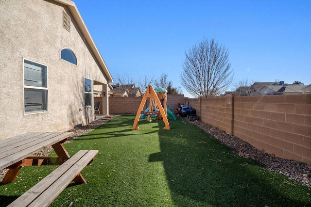 view of yard with a fenced backyard and a playground