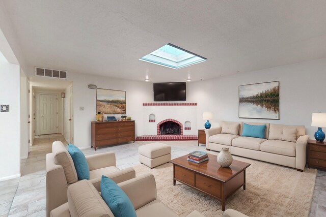 living room with a fireplace, a textured ceiling, and a skylight