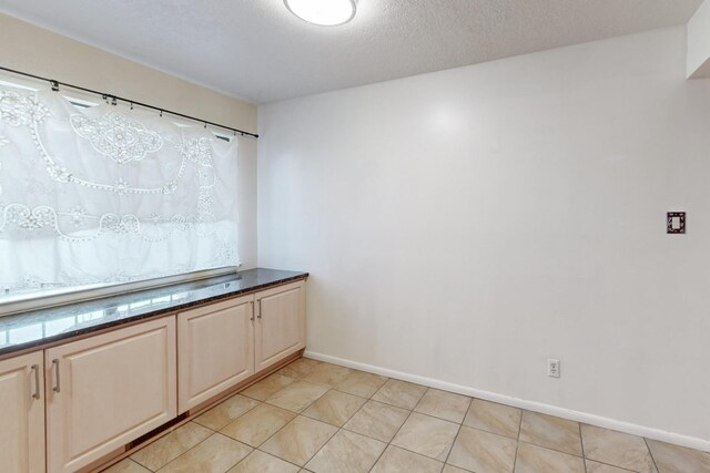 interior space with light tile patterned floors and a textured ceiling