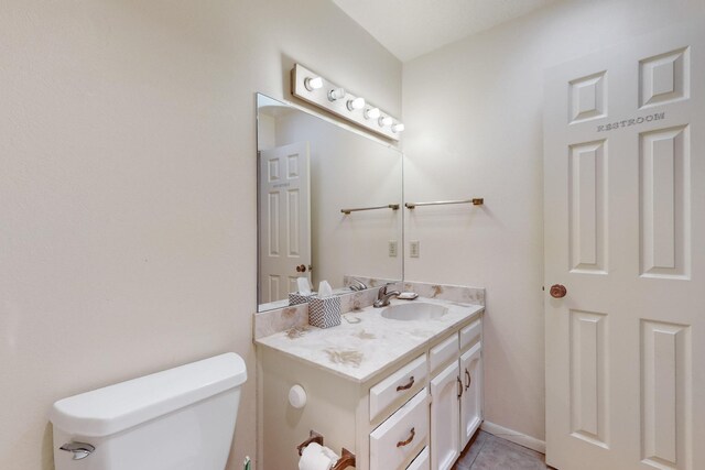 bathroom featuring tile patterned floors, vanity, and toilet