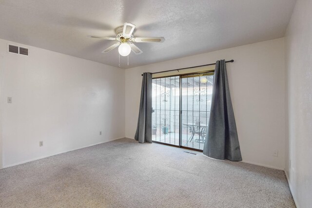 carpeted spare room featuring a textured ceiling and ceiling fan