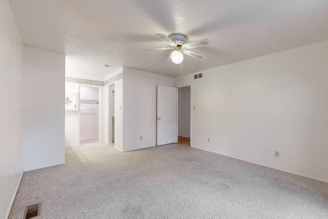 carpeted spare room with ceiling fan and a textured ceiling