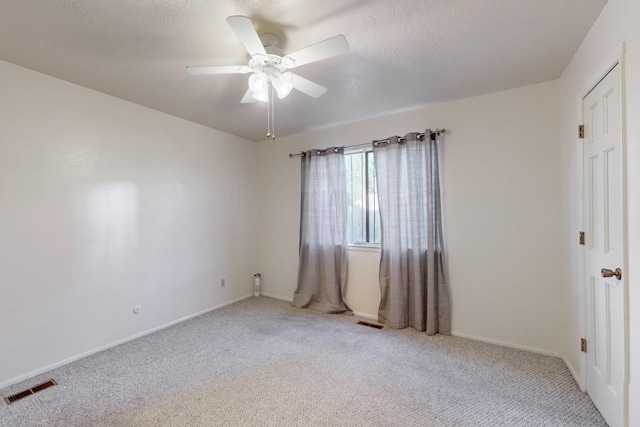 unfurnished room with ceiling fan and light carpet