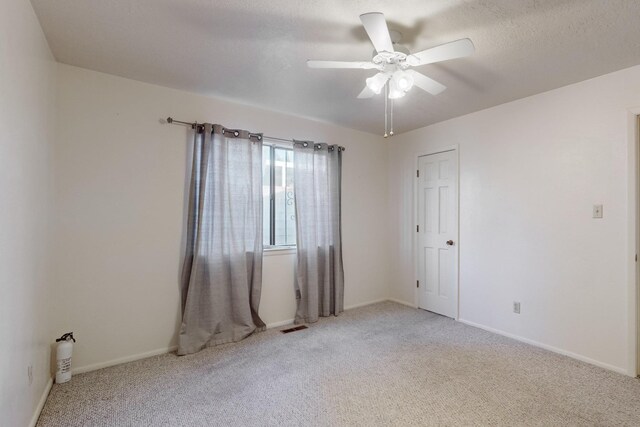 spare room featuring ceiling fan and carpet floors