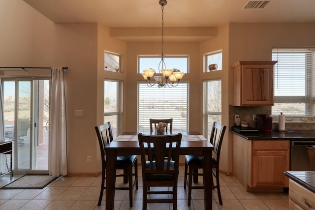 dining space with plenty of natural light, light tile patterned floors, and an inviting chandelier