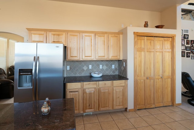 kitchen with decorative backsplash, stainless steel refrigerator with ice dispenser, light tile patterned floors, and light brown cabinetry