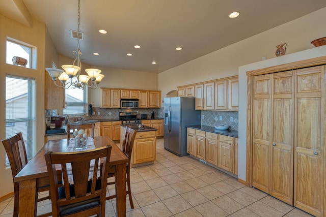 kitchen featuring appliances with stainless steel finishes, tasteful backsplash, decorative light fixtures, a chandelier, and a center island