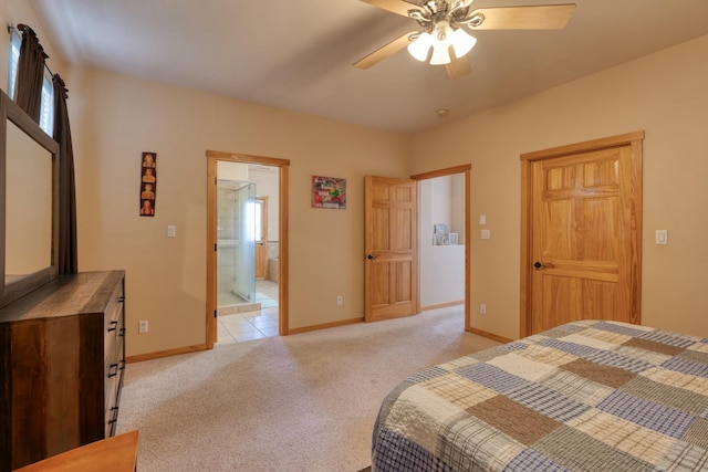 bedroom featuring ceiling fan, light colored carpet, and ensuite bath